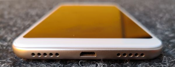 Pohjasta Xiaomi Redmi 5 Plussasta löytyy Micro-USB-liitäntä kaiuttimen ja mikrofonin aukkojen lisäksi.